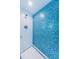 Bright shower features blue mosaic tile accent wall and white subway tile at 5130 Brittany S Dr # 201, St Petersburg, FL 33715