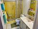 This vibrant yellow tiled bathroom features a shower with seating and modern fixtures at 5980 Shore S Blvd # 510, Gulfport, FL 33707