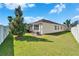 Backyard view with lush lawn, a screened patio, and a mature shade tree at 7115 Nightshade Dr, Riverview, FL 33578