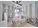 Charming bedroom with gray and white stripes, a ceiling fan, and unique wrought-iron bed at 7115 Nightshade Dr, Riverview, FL 33578