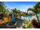 Charming backyard featuring a fire pit, vibrant Adirondack chairs, and a pergola next to a sparkling pool at 9911 Antilles Dr, Seminole, FL 33776