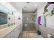 Well-lit bathroom features a marble countertop, a glass shower, and decorative accents at 9911 Antilles Dr, Seminole, FL 33776