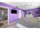 Cozy purple bedroom featuring carpeted floors, a ceiling fan, and an adjoining bathroom at 9911 Antilles Dr, Seminole, FL 33776