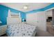 Bright bedroom with seashell-themed bedding, white furniture, a ceiling fan, and an attached closet at 9911 Antilles Dr, Seminole, FL 33776