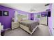 Vibrant purple bedroom with plush carpeting, a ceiling fan, and large windows for natural light at 9911 Antilles Dr, Seminole, FL 33776