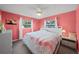 Bright bedroom with flamingo-themed bedding, white furniture, and natural light at 9911 Antilles Dr, Seminole, FL 33776