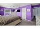 Spacious bedroom with purple walls, a ceiling fan, carpeted floors, and large windows at 9911 Antilles Dr, Seminole, FL 33776