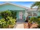 Charming entrance with nautical accents, lush greenery, and a white door at 9911 Antilles Dr, Seminole, FL 33776