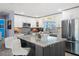 Bright kitchen with a granite island, stainless appliances, and white cabinetry at 9911 Antilles Dr, Seminole, FL 33776