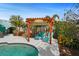 Tranquil backyard getaway featuring an elegant wood pergola with covered lounge chairs, adjacent to a sparkling pool at 9911 Antilles Dr, Seminole, FL 33776