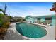 Inviting backyard oasis featuring a sparkling pool, lush greenery, and a charming pergola, ideal for relaxation at 9911 Antilles Dr, Seminole, FL 33776