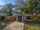 Backyard featuring large shed with concrete path, mature trees, partial fencing, and a work bench at 1213 60Th S St, Gulfport, FL 33707