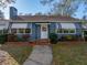 Charming single-story home with blue siding, awnings, a chimney, and a landscaped front yard at , Gulfport, FL 33707