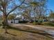 Charming single-story home featuring a driveway, attached garage, and lush, mature trees at 1213 60Th S St, Gulfport, FL 33707