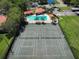 Aerial view of a community featuring tennis courts, a pool, manicured landscaping, and parking at 1003 Hammock Pine Blvd # 1003, Clearwater, FL 33761