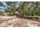 Community entrance featuring a gated entry, landscaped median, and tree-lined street at 1003 Hammock Pine Blvd # 1003, Clearwater, FL 33761