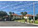 Condominium building with covered parking, mature landscaping, a red tile roof, and community car wash at 1003 Hammock Pine Blvd # 1003, Clearwater, FL 33761