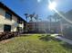 Two-story condo building featuring green space, balconies, mature trees, and walkways under a sunny sky at 1003 Hammock Pine Blvd # 1003, Clearwater, FL 33761