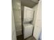 Stacked washer and dryer unit inside a laundry closet with shelving at 1003 Hammock Pine Blvd # 1003, Clearwater, FL 33761
