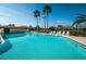 Community pool with inviting blue water, surrounded by lounge chairs and tall palm trees at 1003 Hammock Pine Blvd # 1003, Clearwater, FL 33761