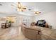 Open-concept living room featuring tile flooring, ceiling fans, and sliding glass doors to the pool area at 109 Live Oak Ln, Largo, FL 33770