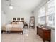 Bright main bedroom with tile floors, a ceiling fan, large windows, and a decorative mirror and dresser at 109 Live Oak Ln, Largo, FL 33770