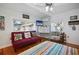 Bedroom featuring a red futon, colorful decor, hardwood floors, and natural light at 1166 Granada St, Clearwater, FL 33755