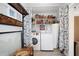 Well-organized laundry room with washer, dryer, shelving, and decorative accents at 1166 Granada St, Clearwater, FL 33755