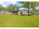 Spacious backyard with a covered patio, a large tree, and a well-maintained lawn at 1520 Arnold Ave, Brooksville, FL 34601