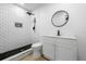 Modern bathroom featuring a subway tile shower, mosaic accents, and a sleek vanity with a round mirror at 1520 Arnold Ave, Brooksville, FL 34601