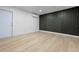 Bright bedroom with light wood floors, a sleek black accent wall, and a modern mini-split air conditioner at 1520 Arnold Ave, Brooksville, FL 34601