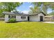 Charming single-story home with a well-manicured lawn, dark shutters, and an attached garage at 1520 Arnold Ave, Brooksville, FL 34601