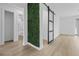 Hallway features a decorative green wall and a sliding barn door that leads to a bathroom with modern fixtures at 1520 Arnold Ave, Brooksville, FL 34601
