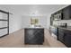 Stylish kitchen features a black marble island, modern appliances, and a sliding barn door for added privacy at 1520 Arnold Ave, Brooksville, FL 34601