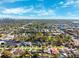 Aerial view of a residential neighborhood with mature trees, sidewalks, and a city skyline in the background at 2713 W Osborne Ave, Tampa, FL 33614