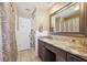 Bathroom with marble countertop vanity, framed mirror, and white tiled shower at 2713 W Osborne Ave, Tampa, FL 33614