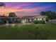 Charming one-story home with a well-maintained lawn and beautiful evening sky at 2713 W Osborne Ave, Tampa, FL 33614