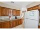 Bright kitchen with white appliances, wooden cabinets, and granite countertops at 2713 W Osborne Ave, Tampa, FL 33614