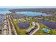 Expansive aerial view showcasing a waterfront community with tennis courts and a beautiful pond at 4744 Snook Se Dr, St Petersburg, FL 33705