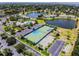 Aerial view of the community featuring tennis courts, a pool, ponds, and lush greenery, showcasing the amenities at 4744 Snook Se Dr, St Petersburg, FL 33705