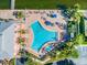 Aerial view displays pool area with blue lounge furniture and a calm ocean at 4744 Snook Se Dr, St Petersburg, FL 33705