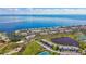 Stunning aerial view of waterfront condos, a serene lake, and recreational amenities like tennis courts at 4744 Snook Se Dr, St Petersburg, FL 33705