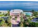 Breathtaking aerial view of a pink building with a pool, docks, and beautifully manicured landscaping overlooking the bay at 4744 Snook Se Dr, St Petersburg, FL 33705