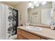 Bathroom with a dark floral shower curtain, single sink vanity, and large mirror at 4744 Snook Se Dr, St Petersburg, FL 33705