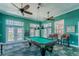 Bright game room features a pool table, ceiling fans, and ocean views from the multiple windows and doors at 4744 Snook Se Dr, St Petersburg, FL 33705