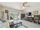 Open living room with a lake view from the sliding glass doors, a ceiling fan, and modern furniture at 4744 Snook Se Dr, St Petersburg, FL 33705