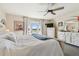 Bright main bedroom featuring a ceiling fan and a balcony with serene views of a lake at 4744 Snook Se Dr, St Petersburg, FL 33705