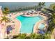 Aerial view of the outdoor swimming pool with lounge chairs and spa surrounded by lush landscaping at 4744 Snook Se Dr, St Petersburg, FL 33705