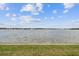 Serene water view with lush green grass, a calming atmosphere, and cloudy sky at 4744 Snook Se Dr, St Petersburg, FL 33705