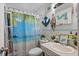 Cozy bathroom with tropical themed shower curtain, anchor decoration, and a white sink and toilet at 5559 17Th N Ave, St Petersburg, FL 33710